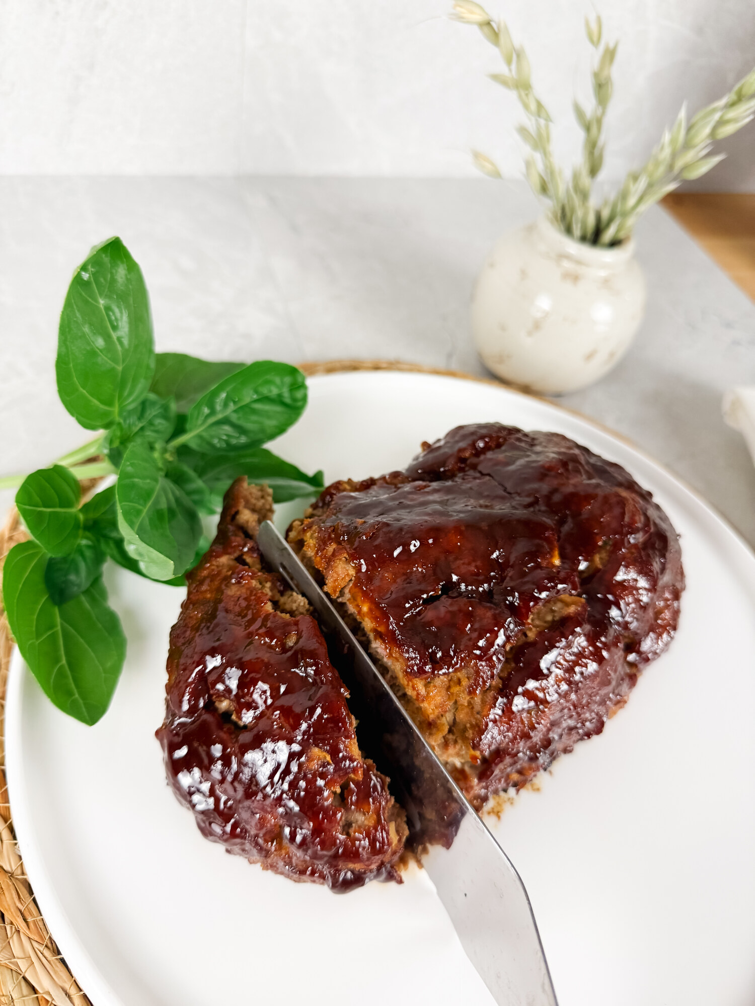 A knife cutting into the balsamic meatloaf, showing the tender interior