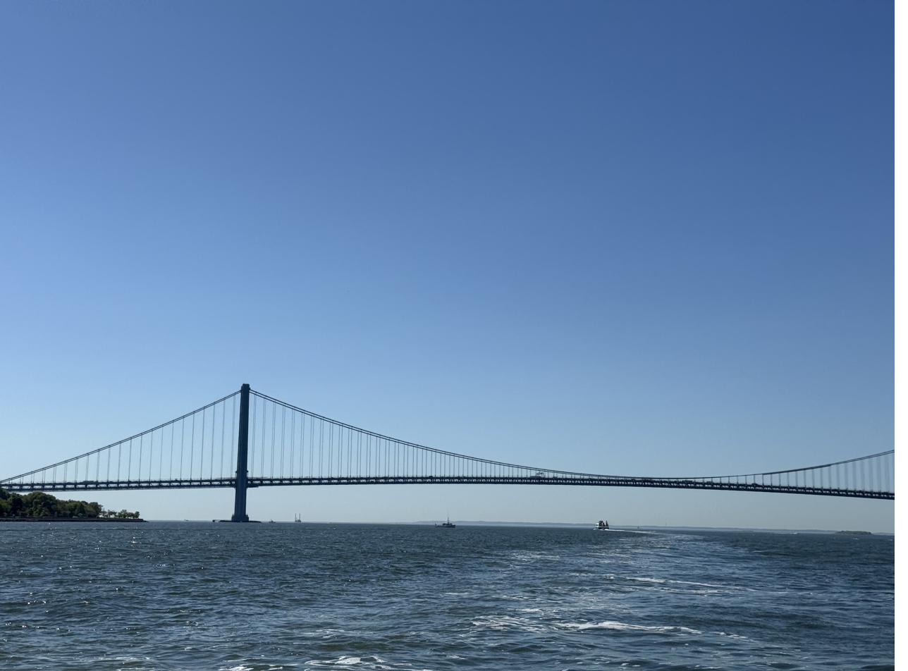 The Verrazzano Bridge stretching across a wide blue sky over the water