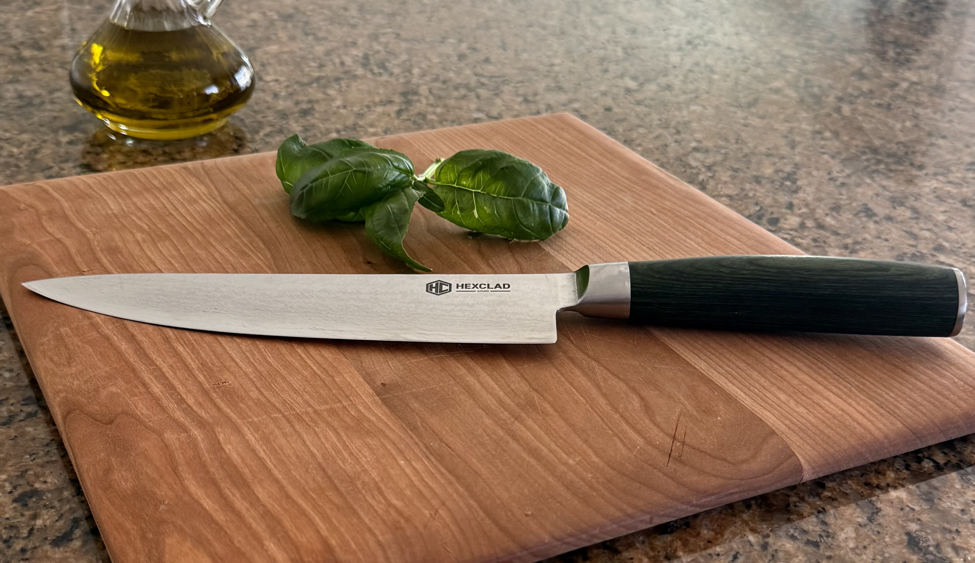 A knife and fresh basil on a wooden cutting board