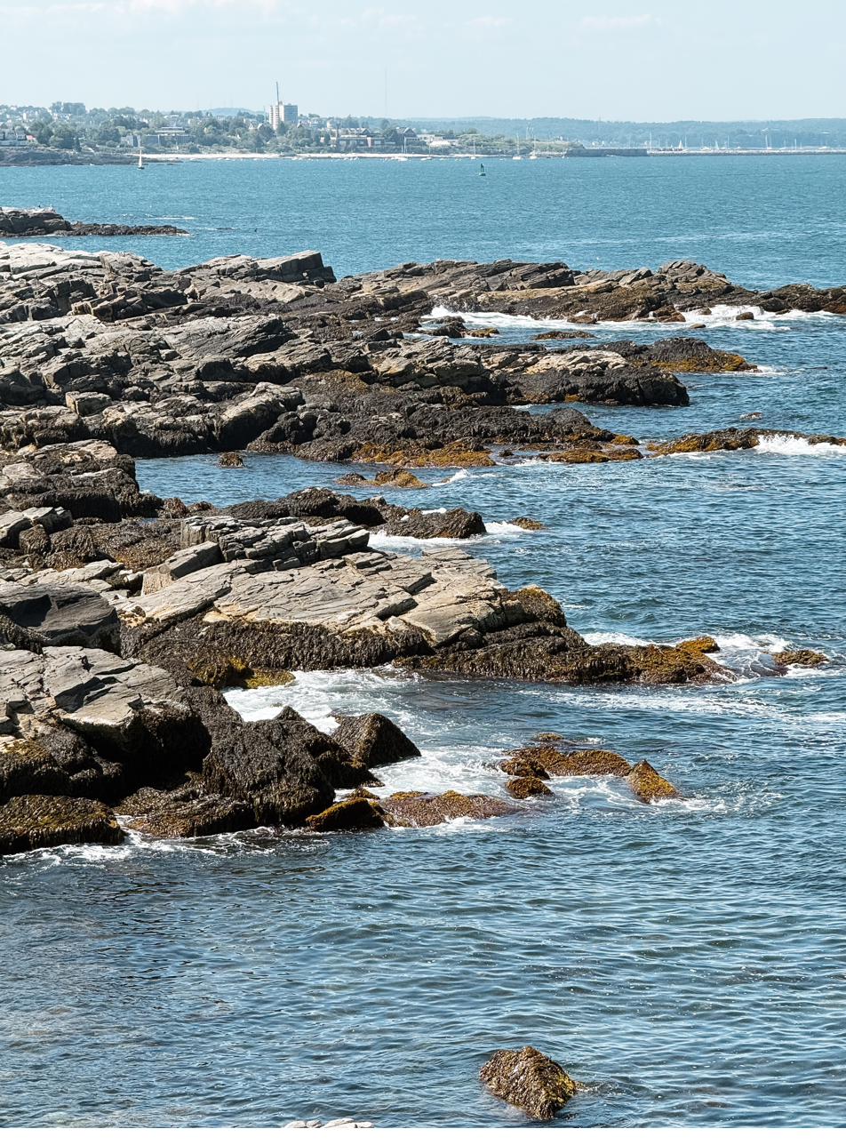 Waves breaking over the ledge, the far shore across the water