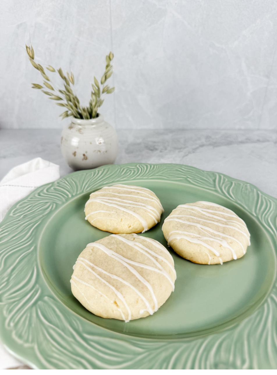 Three glazed vanilla bean sugar cookies on a pale green plate