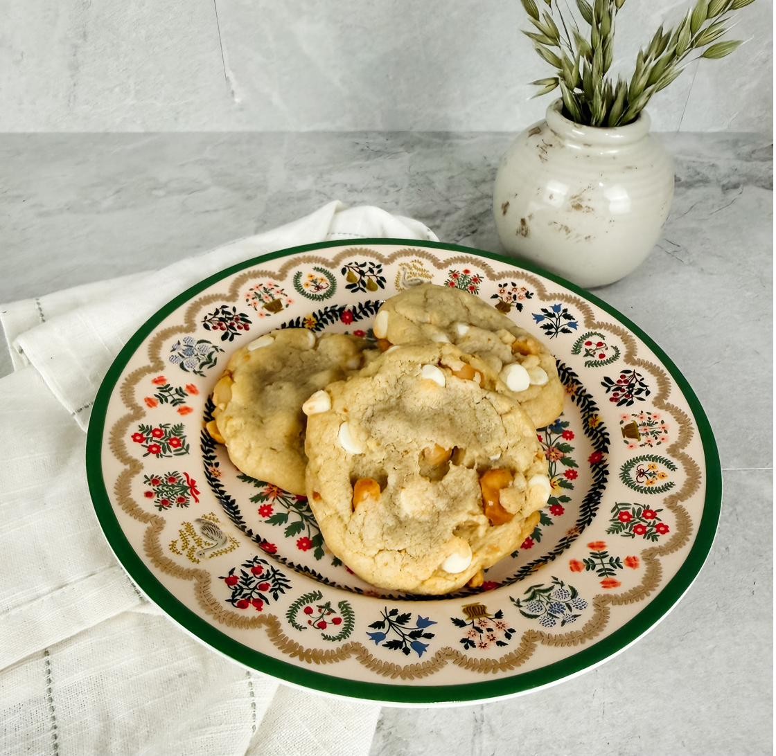 A close plate of white chocolate macadamia cookies with a linen napkin